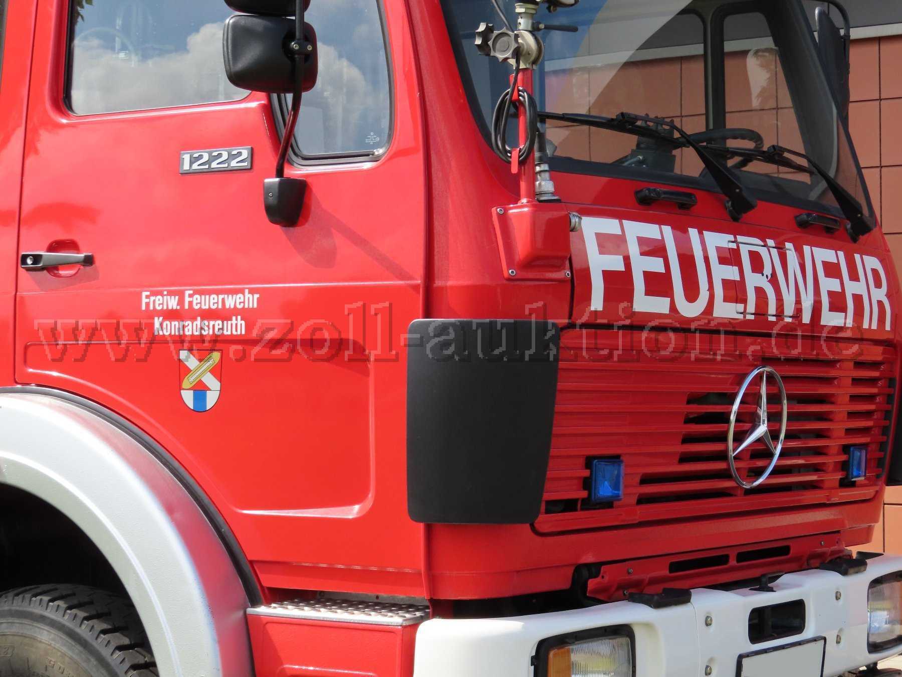 Rotes Feuerwehrfahrzeug Mercedes-Benz 1222
Nahansicht vorne rechts
Blick auf das Führerhaus und die Beifahrertür des Fahrzeugs
