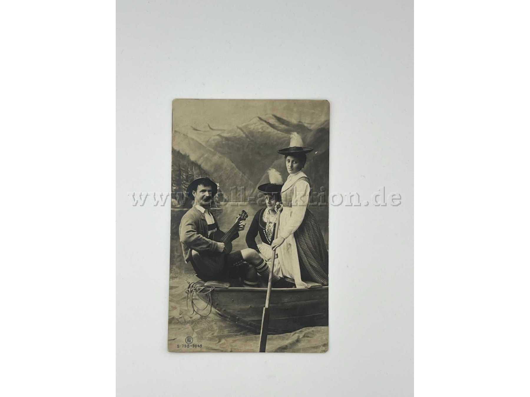 Zwei Frauen und ein Mann in Tracht auf einem Boot