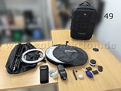 Übersicht Mischposten, von links nach rechts: Ringlicht mit Stativ und Tasche, Falt-Diffuser mit Tasche, Blitzaufsatz, Reinigungszubehör, Akkus, Fernauslöser, Objektivaufsatz, Rollkoffer