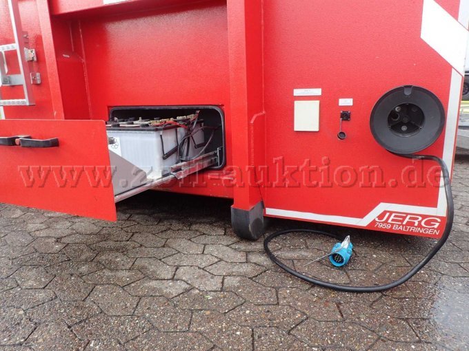 Abrollbehälter Pulver-Schaum, Ansicht vorne mit geöffnetem Batteriefach und abgerolltem Zugfahrzeug Anschlusskabel