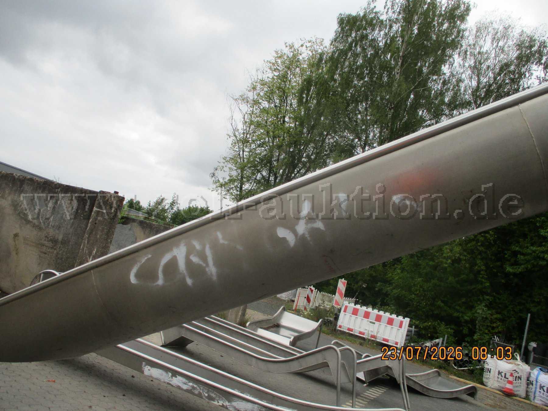 Nahaufnahme der weißen Schmierereien (Graffiti) an der Unterseite der Rutschenwange.