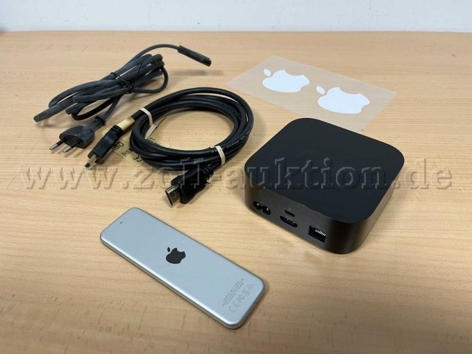 Rückseite Apple TV mit Rückseite Fernbedienung, Kabeln und Aufkleber.