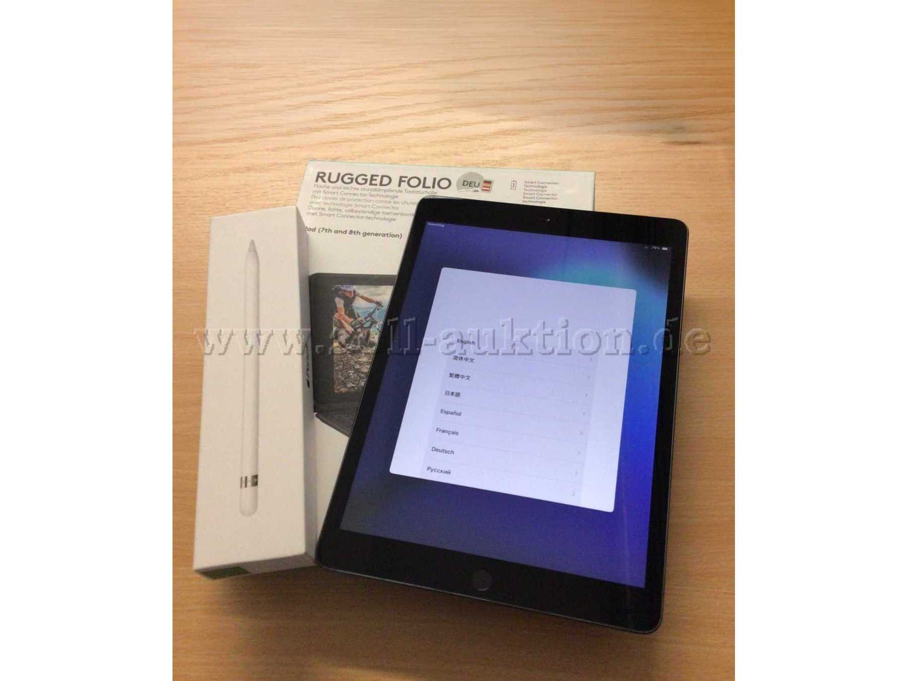 iPad 7 Vorderseite angeschaltet mit Tastaturhülle und Apple Pencil jeweils im Karton