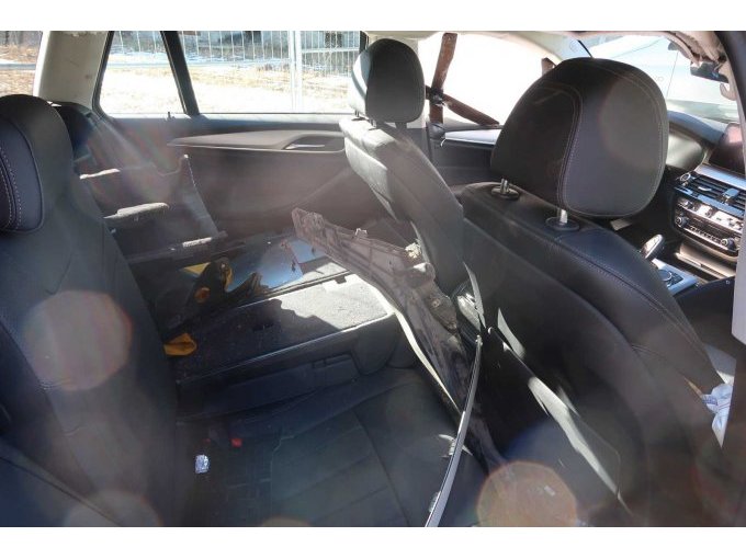 Bereich Rücksitzbank mit teilweise umgeklappter Rücksitzlehne und Restbauteilen