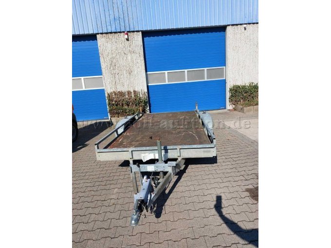 Frontansicht, zu sehen ist der komplette Anhänger mit Holzboden, Kratzern und Gebrauchsspuren