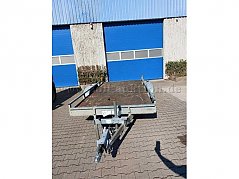 Frontansicht, zu sehen ist der komplette Anhänger mit Holzboden, Kratzern und Gebrauchsspuren