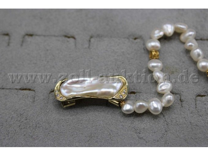 Anhänger als Nahbild zu sehen mit einer großen Perle in der Mitte und in Gold eingefasst, besetzt mit Diamanten