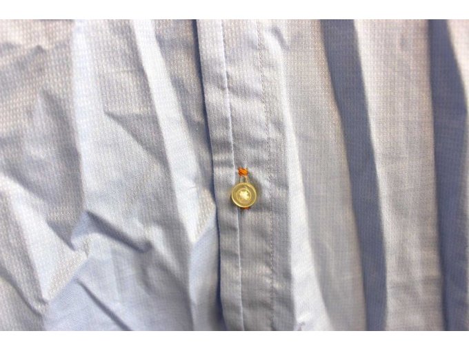 Orangefarbender Faden am Knopfloch