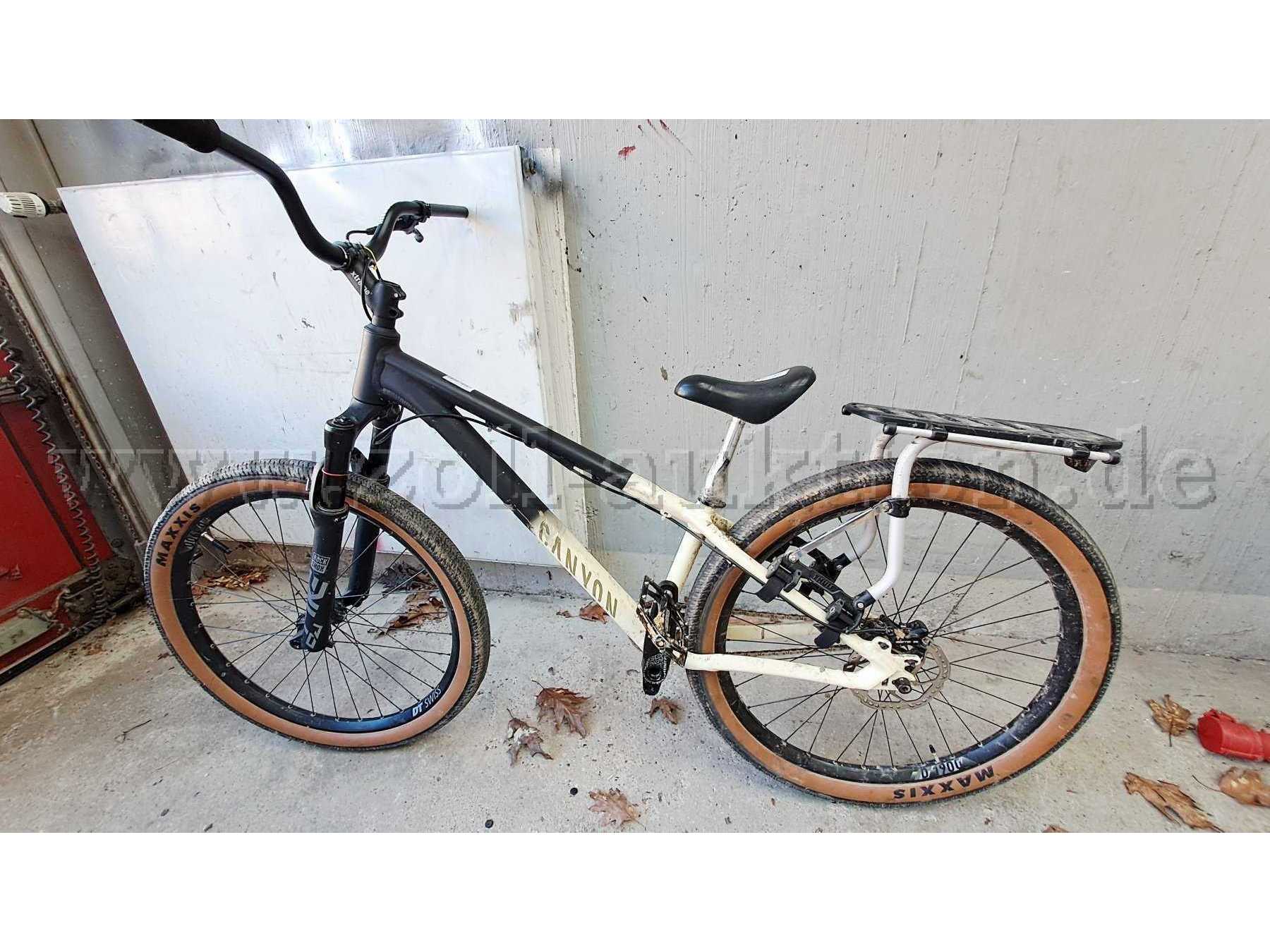 Fahrrad in Seitenansicht, Rahmen schwarz und beige, Logo Canyon, Gepäckträger von Thule