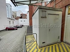 Auf dem Bild ist die Front eines Containers mit einer Eingangstür, Lüftungsklappe, Typenschild zu sehen