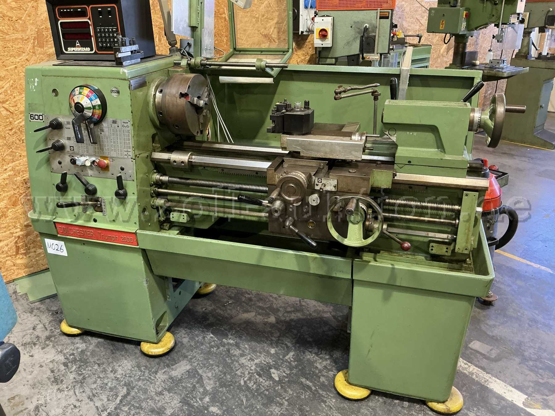 Frontalansicht der Maschine. Die Interne Maschinennummer 026 ist an der Maschine angebracht. Man erkennt Farbabblätterungen und Gebrauchsspuren sowie das Messgerät Superwizard als Aufbau.