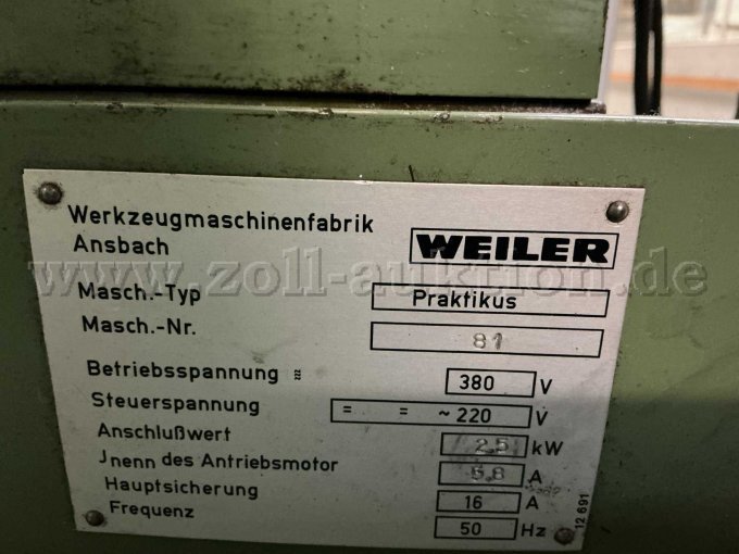 Typenschild mit Hersteller (Weiler), Maschinen-Typ (Praktikus) und Maschinen-Nummer (81). Zudem sind Farbabblätterungen und Verschmutzungen mit Betriebsmitteln zu erkennen.