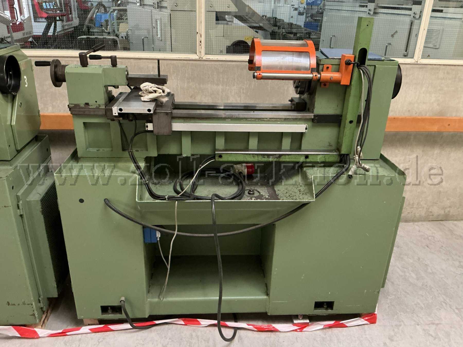 Ansicht der Maschine von vorne, es sind Verschmutzungen durch Betriebsstoffe und Farbabblätterungen in der Wanne zu erkennen.