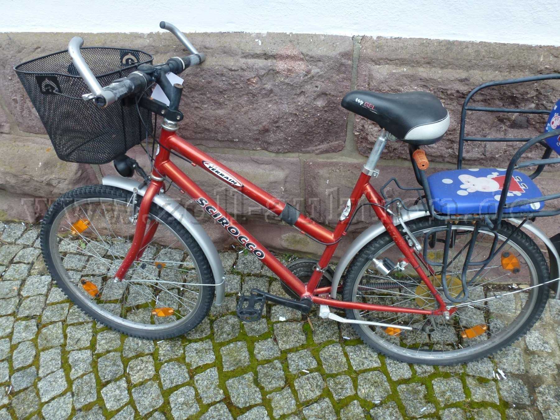 Fahrrad von der Seite mit Einkaufskorb vorne und Kindersitz hinten