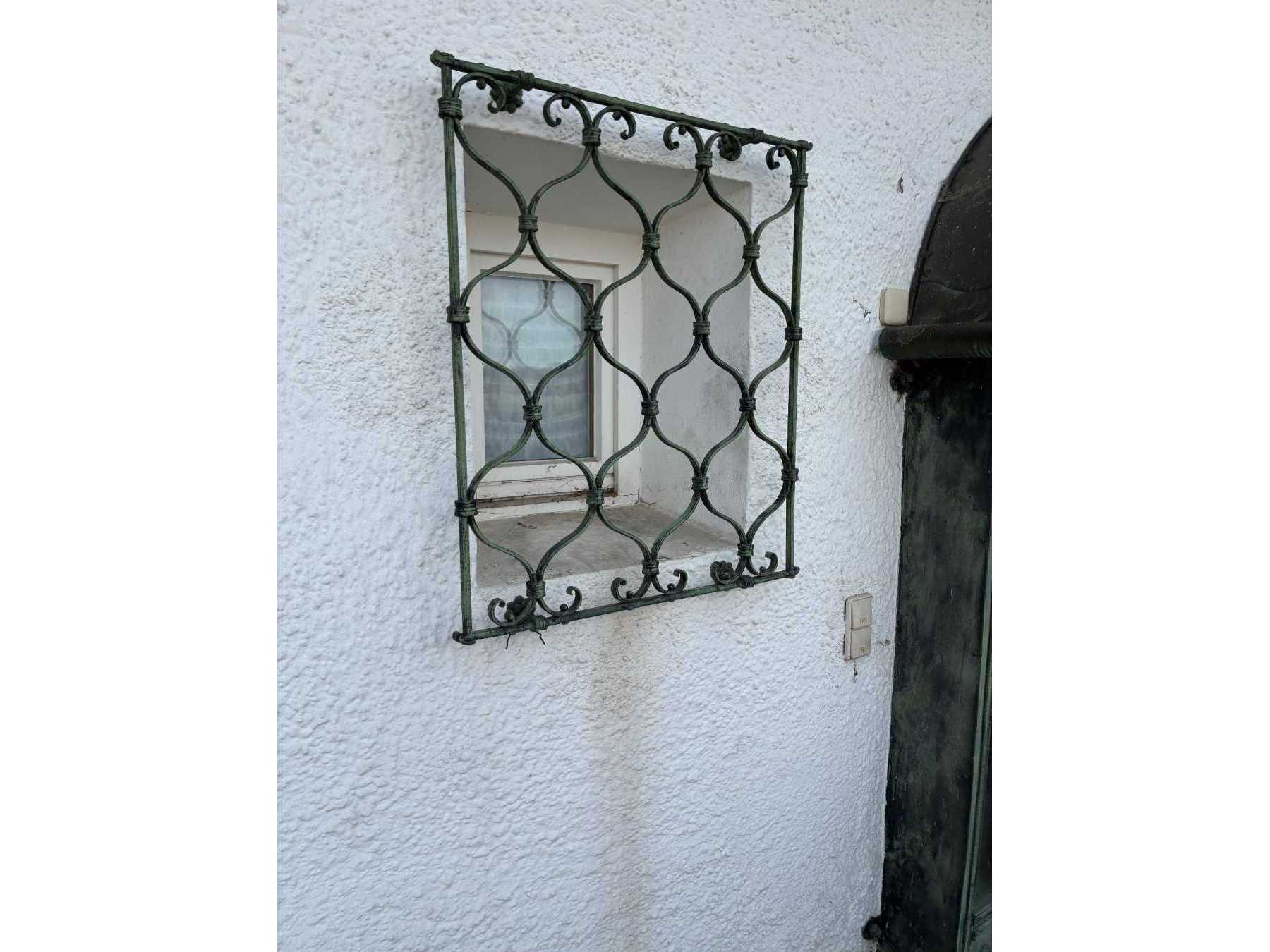 Zu sehen ist das Fenstergitter mit witterungsbedingten Abnutzungen.