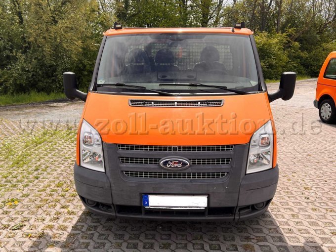 Der orangefarbene Ford Transit Tourneo als Dreisitzer ist auf diesem Bild frontal fotografiert.