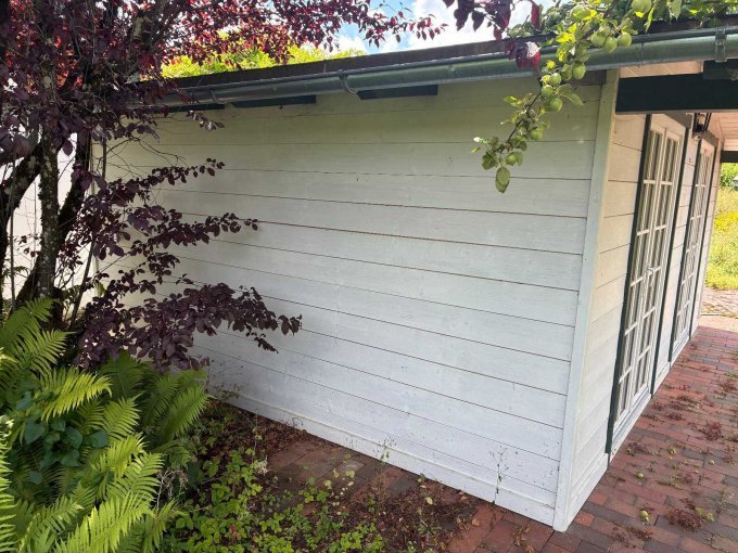 Zu sehen ist die rechte Seitenansicht der Hütte ohne Fenster mit witterungsbedingten Abnutzungen.