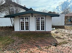 Zu sehen ist die Vorderseite der Hütte mit zwei Türen und witterungsbedingten Abnutzungen.