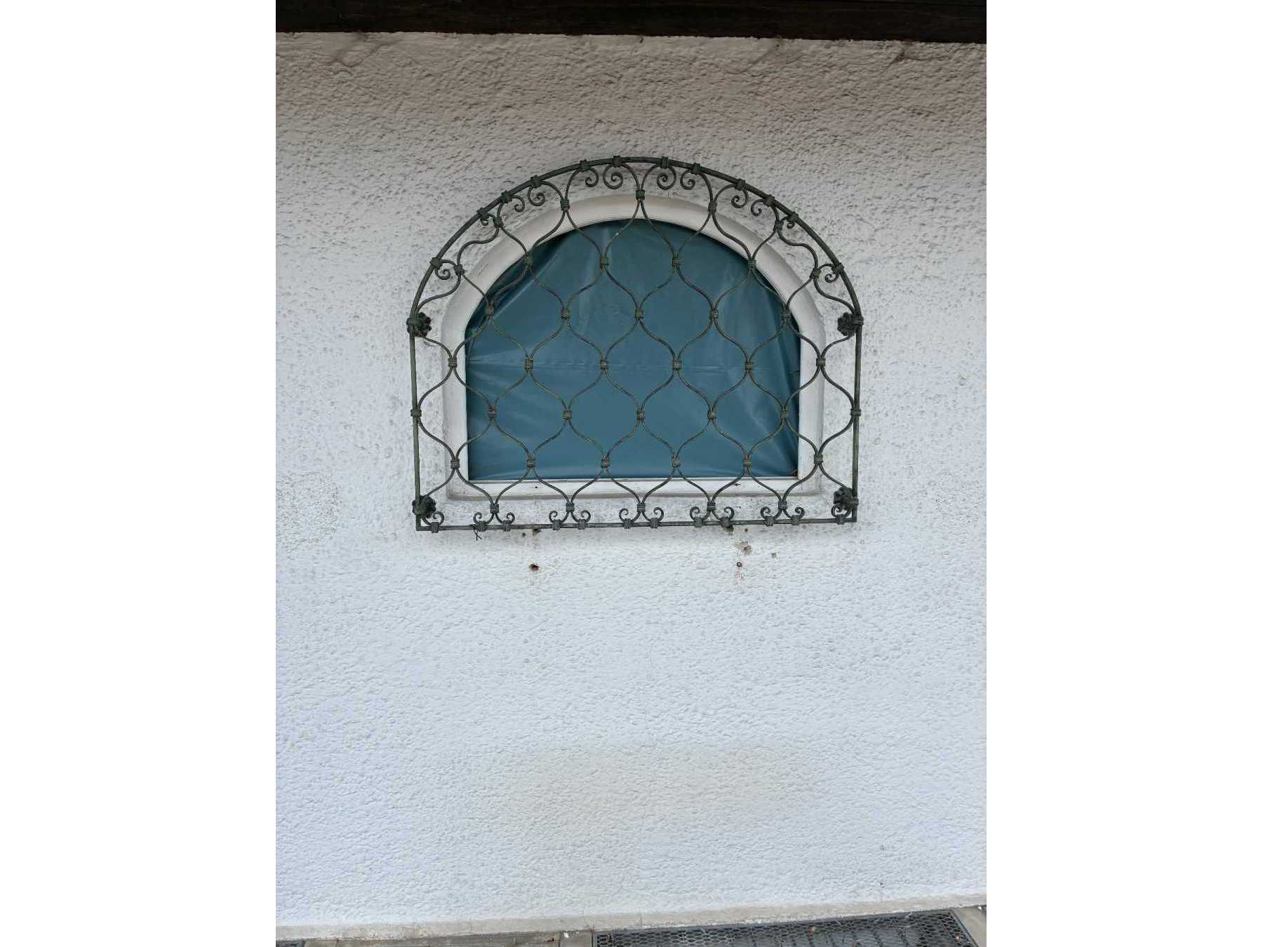 Zu sehen ist das Fenstergitter mit witterungsbedingten Abnutzungen.