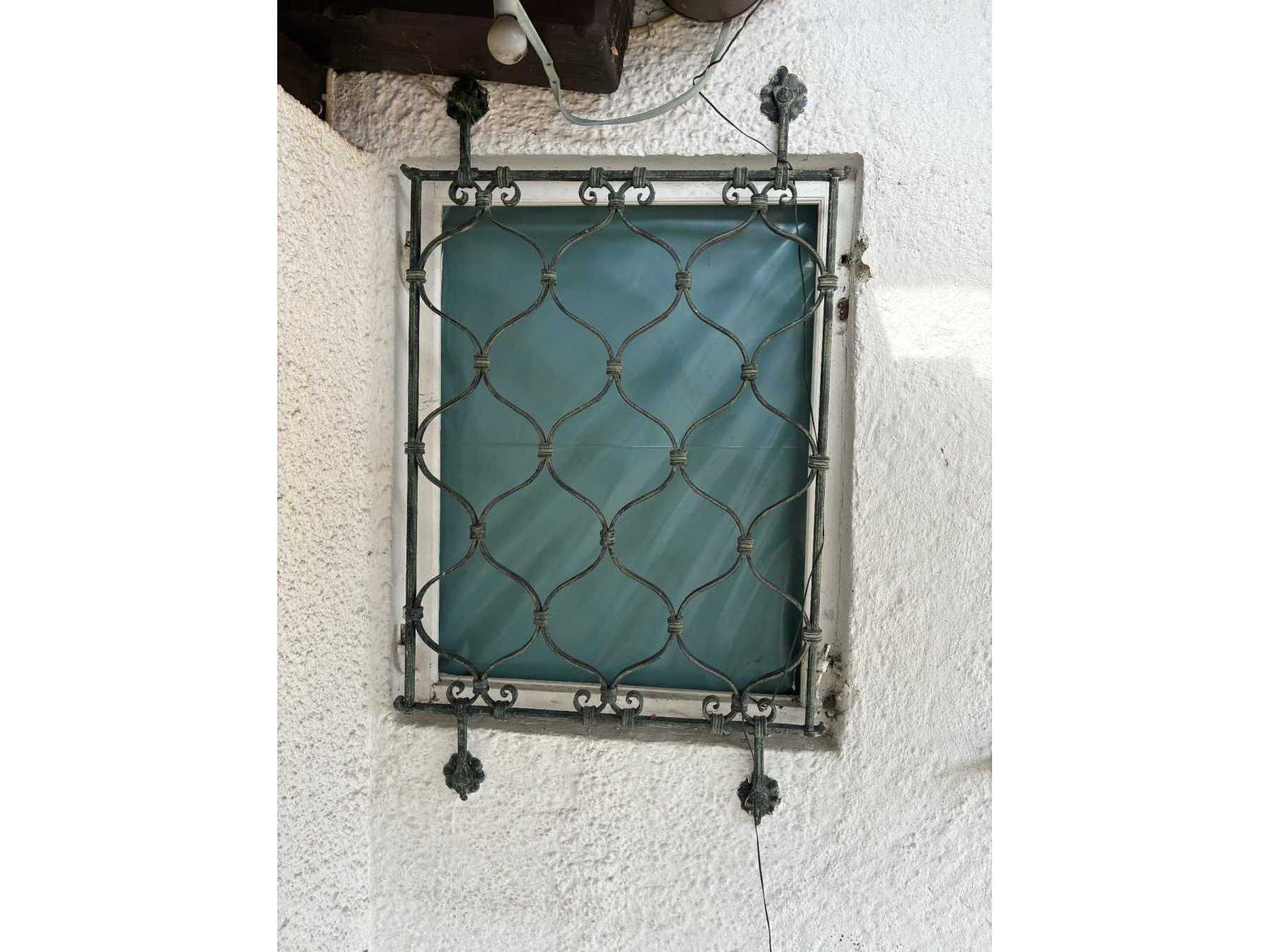 Zu sehen ist das Fenstergitter mit witterungsbedingten Abnutzungen.
