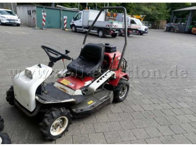 Ansicht vorneseitlich. Zur Versteigerung steht nur der beschriebene Gestrüppaufsitzrasenmäher.