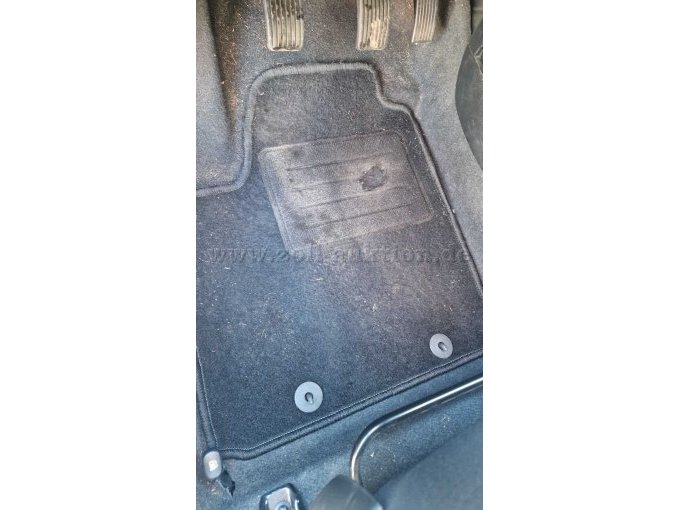 Loch in der Fußmatte der Fahrerseite