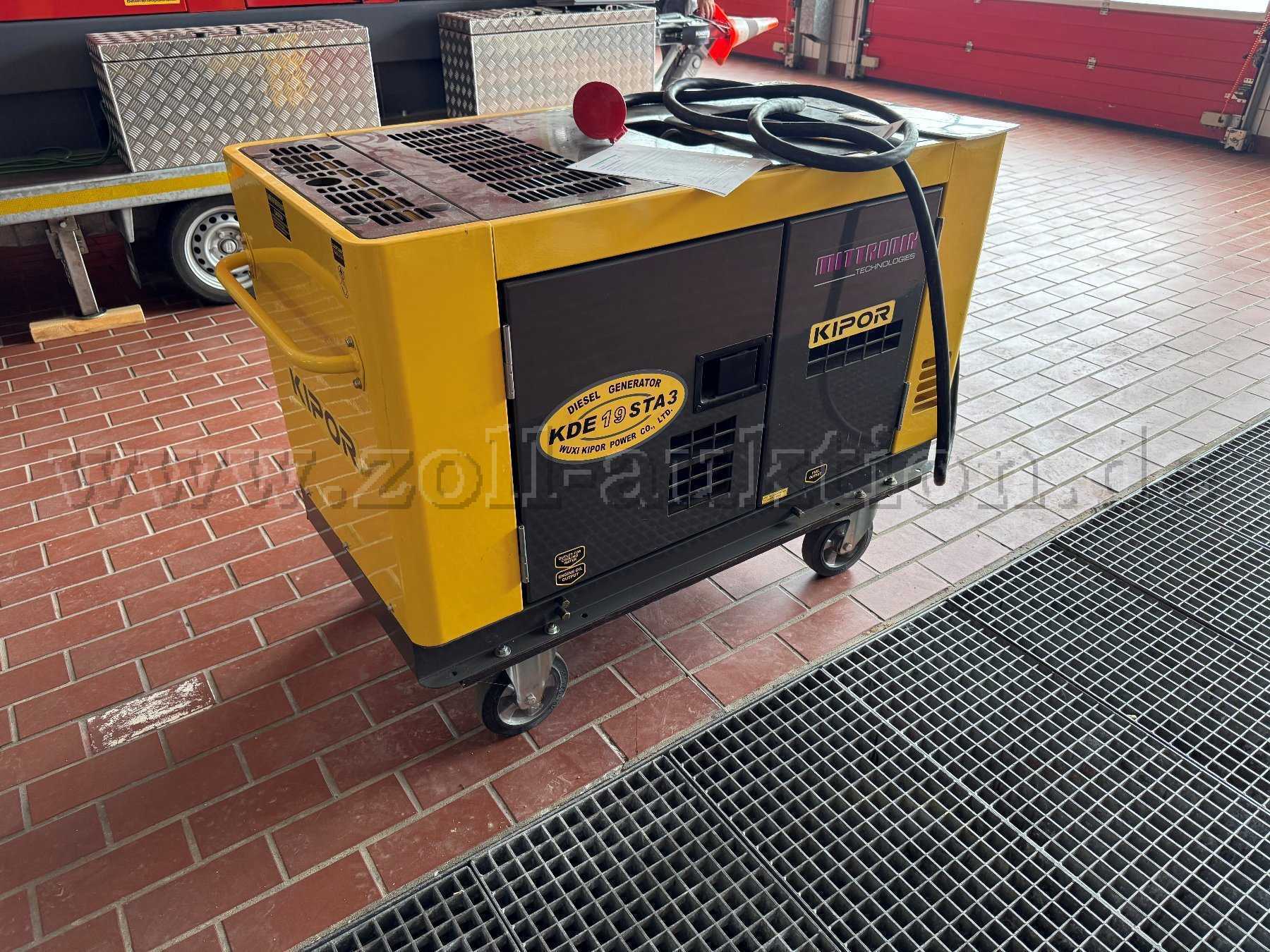 Auf diesem Bild ist der Generator als Seitenansicht zu erkennen. Auf dem Generator liegt ein Einspeisekabel. Hier sind die Seitentüren in grau zu erkennen, hinter diesen Türen befindet sich der Motor
