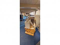 Vorne im Bild die Außeneinheit mit Abflussschlauch und Halterung, dahinter die Inneneinheit.