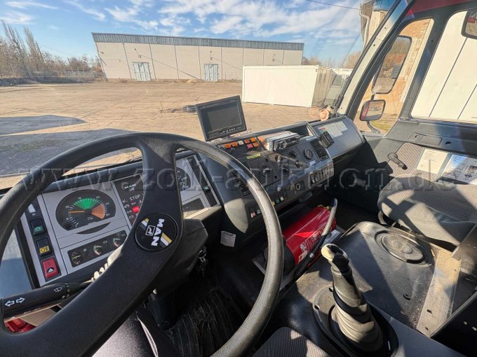 Innenansicht des Fahrerhauses des Feuerwehrfahrzeuges. Zu sehen sind das Armaturenbrett mit Instrumentenanzeige, Lenkrad, Funk- und Bedieneinheiten sowie die Mittelkonsole mit Schaltgetriebe.