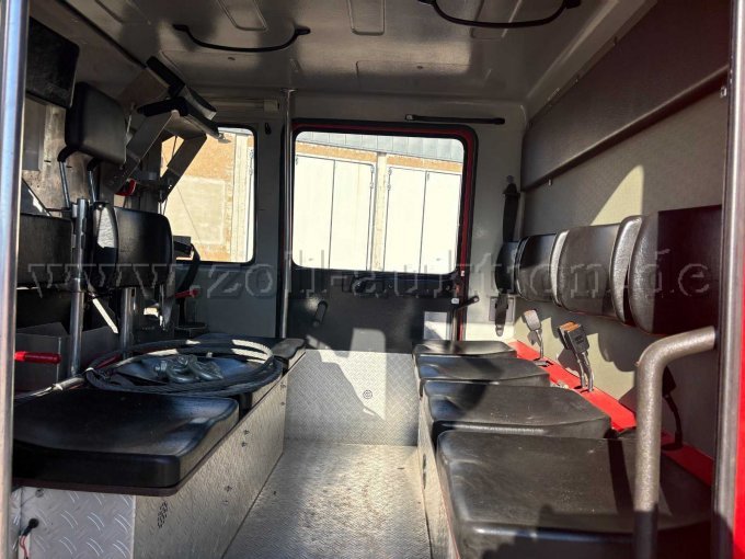 Innenansicht des Mannschaftsraums mit Sitzbänken und Halterungen.