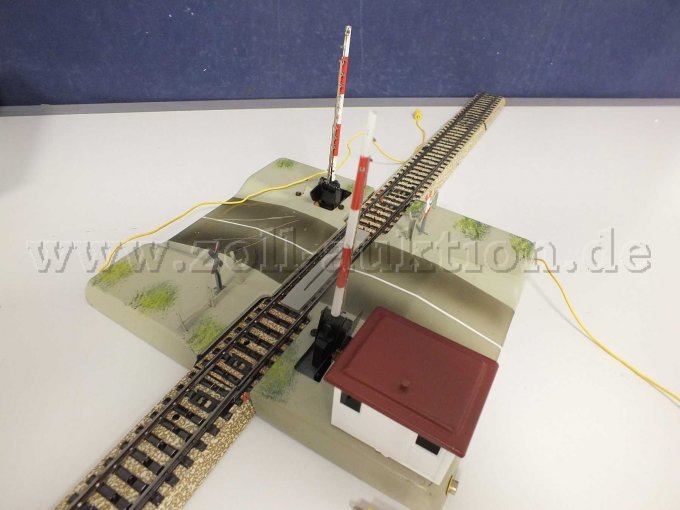 Seitliche Ansicht des Anschluss an M-Gleise und der 2 elektromagnetisch betätigte Schranken mit je ein Warnkreuz.