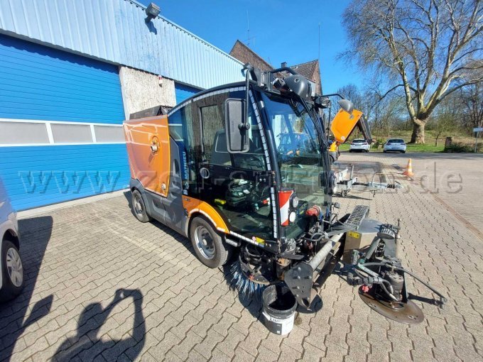 Schrägbild (vorne/linksseitig); zu sehen kleinere Beulen; Kratzer, Lackschäden mit teilweise Korrosion; Öldefekt am Besen vorne rechts