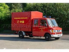 Rotes Feuerwehrfahrzeug der Freiwilligen Feuerwehr Hünfelden mit gelber Aufschrift 'FEUERWEHR HÜNFELDEN 112' auf der Plane