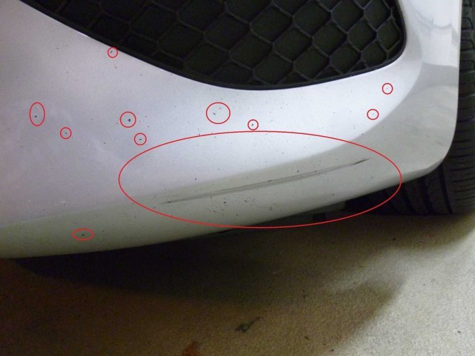 Stoßfänger vorne links unten: Kratzer mit Lackbeschädigung und Steinschläge