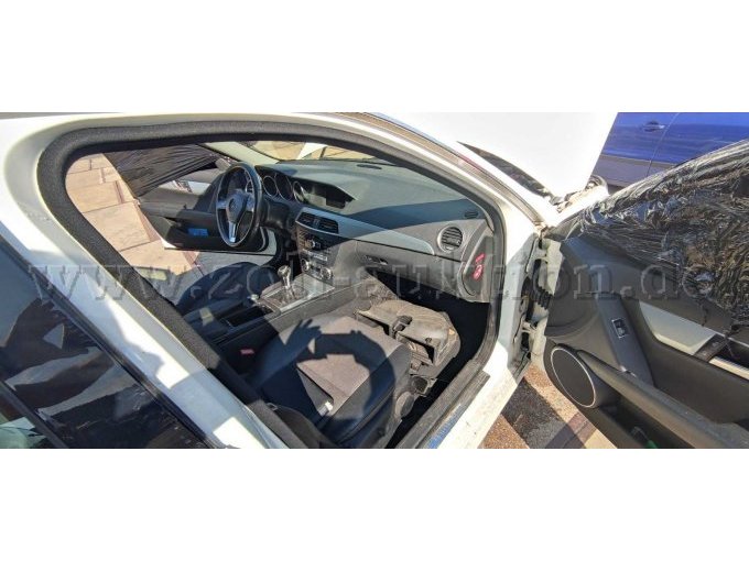 Blick von Außen auf den Beifahrerplatz, Fahrzeugteile im Fußraum, offenes Fenster wegen Fahrzeugreinigung mit Folie abgedichtet