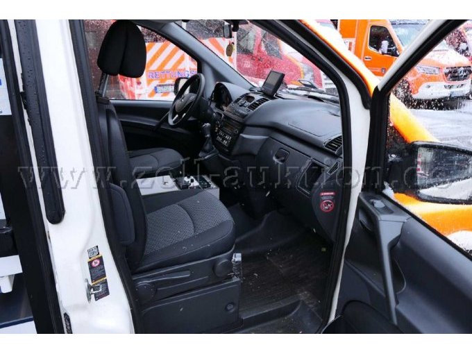 Ansicht des Beifahrer- und Fahrerplatzes mit Armaturenbrett durch die geöffnete Beifahrertür.