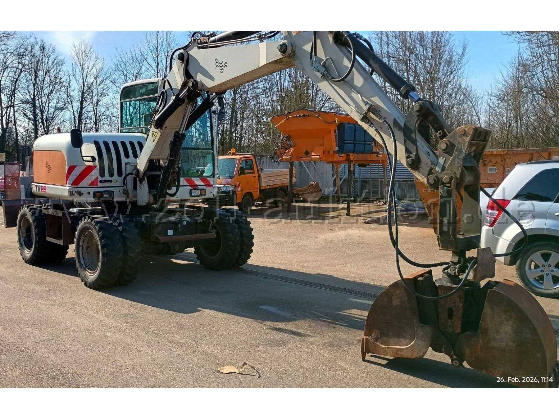 Fahrzeug von vorne links mit Anbaugerät Greifer