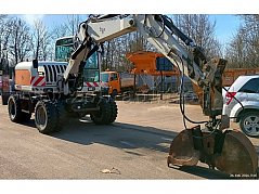 Fahrzeug von vorne links mit Anbaugerät Greifer