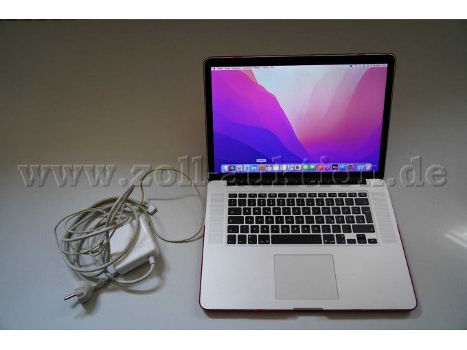 MacBook Pro mit roter Hülle und Netzkabel.
