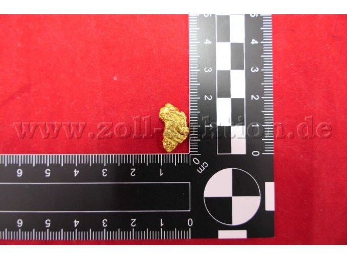 Goldnugget mit Maßstab