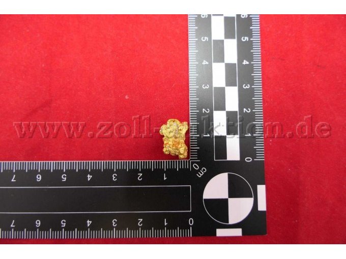 Goldnugget mit Maßstab