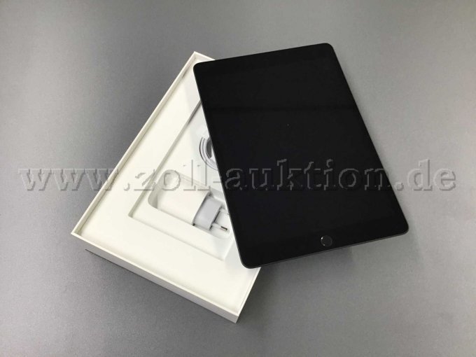 iPad 9 liegt schräg auf geöffneten Karton. Ladekabel und Adapter sind zusehen