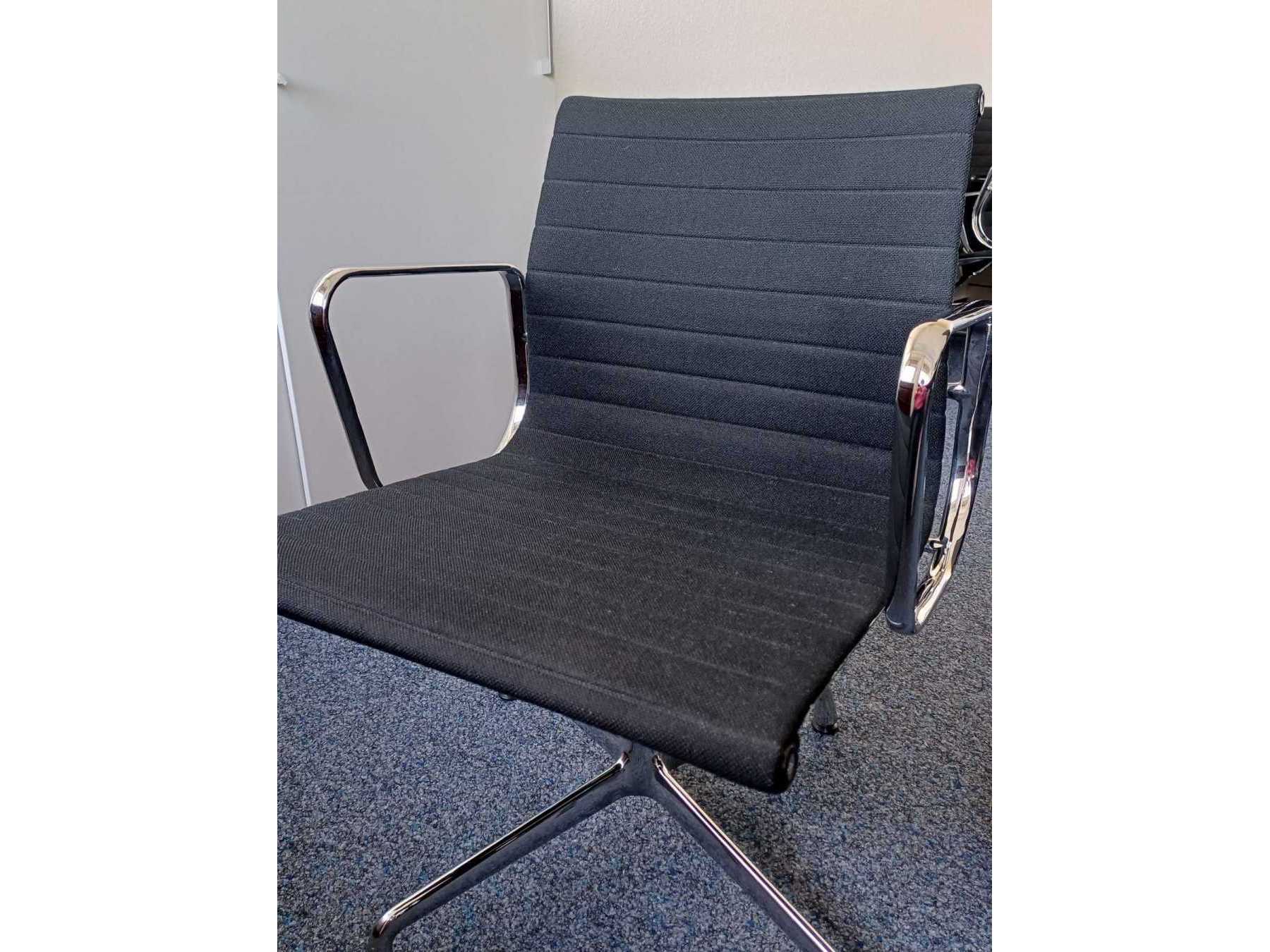 Seitlicher Blick auf den Stuhl Vitra Aluminium von Charles und Ray Eames EA 108 mit verchromten Armlehnen