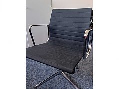 Seitlicher Blick auf den Stuhl Vitra Aluminium von Charles und Ray Eames EA 108 mit verchromten Armlehnen