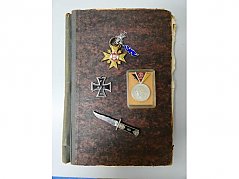 Sammlung Militärorden_ Gesamtansicht auf eisernes Kreuz, NVA-Medaille, arabisches Messer, Narrenkreuz und Notizbuch