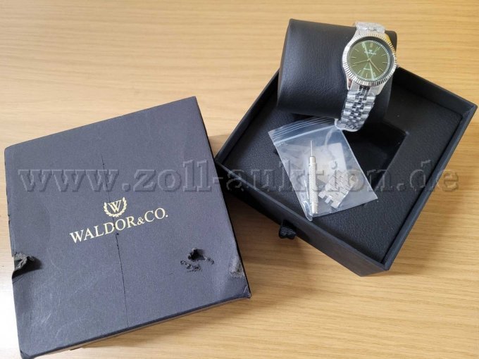 Ansicht Schatulle mit erkennbaren Beschädigungen und Uhr mit Uhrmacher Schraubendreher und Ersatz-Armbandglied