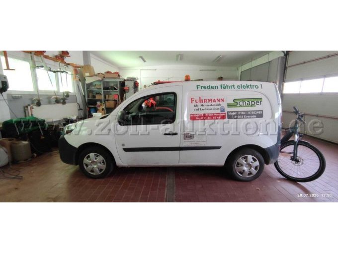 Linke Seitenansicht eines weißen Renault Kangoo mit Werbebeschriftung, einer orangefarbenen Rundumleuchte auf dem Dach