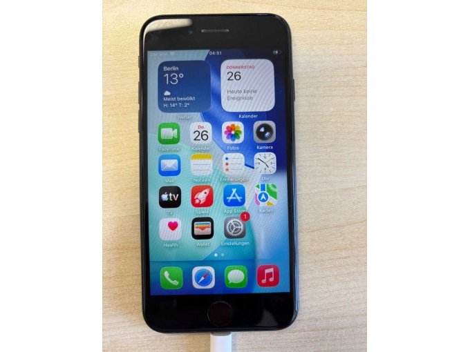 Blick auf das iPhone, als es noch nicht zurückgesetzt war. Es wird gerade mittels Kabel geladen.