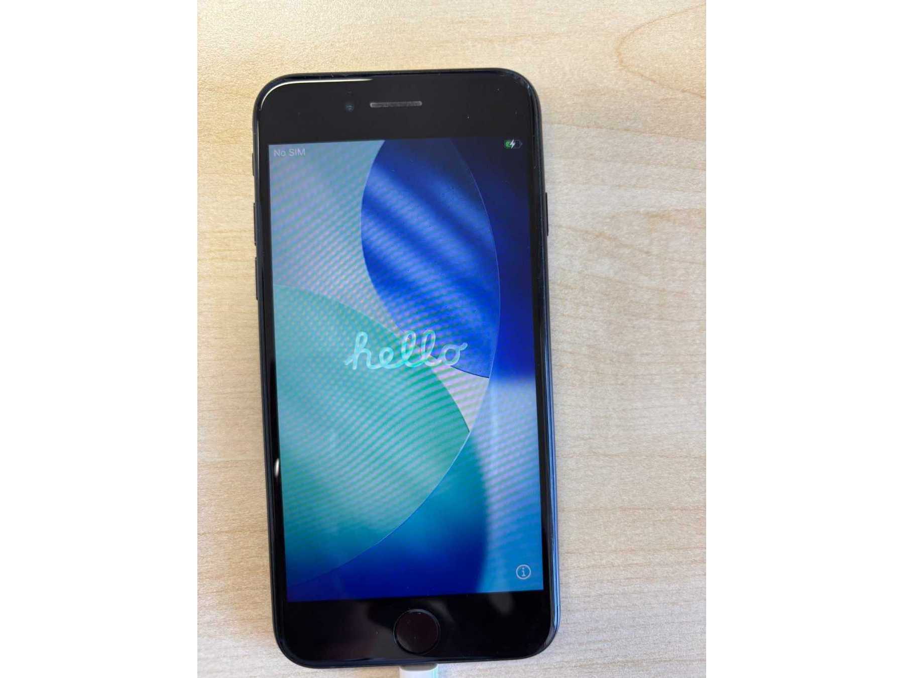 iPhone aus der Sicht von oben mit Startbildschirm, gerät wird geladen über Kabel.