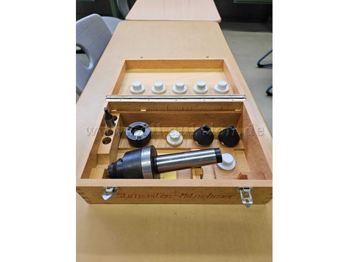 Stirnseitenmitnehmer mit Zubehör in geöffneter Holzschachtel, Draufsicht von schräg oben auf Seite mit Inhalt und Deckelinnenseite